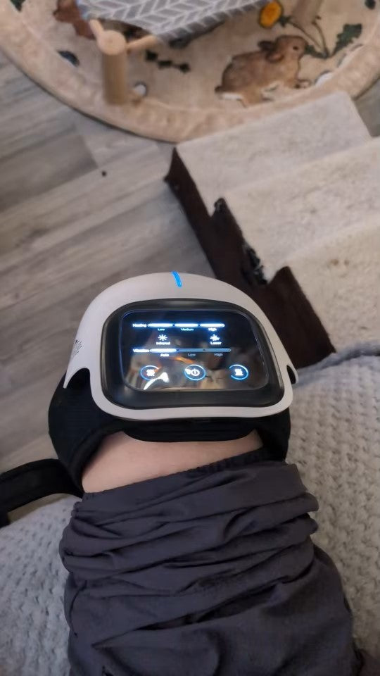 Customer using a knee massager with an illuminated control panel, showcasing adjustable heating, vibration, and laser therapy settings for knee pain relief.